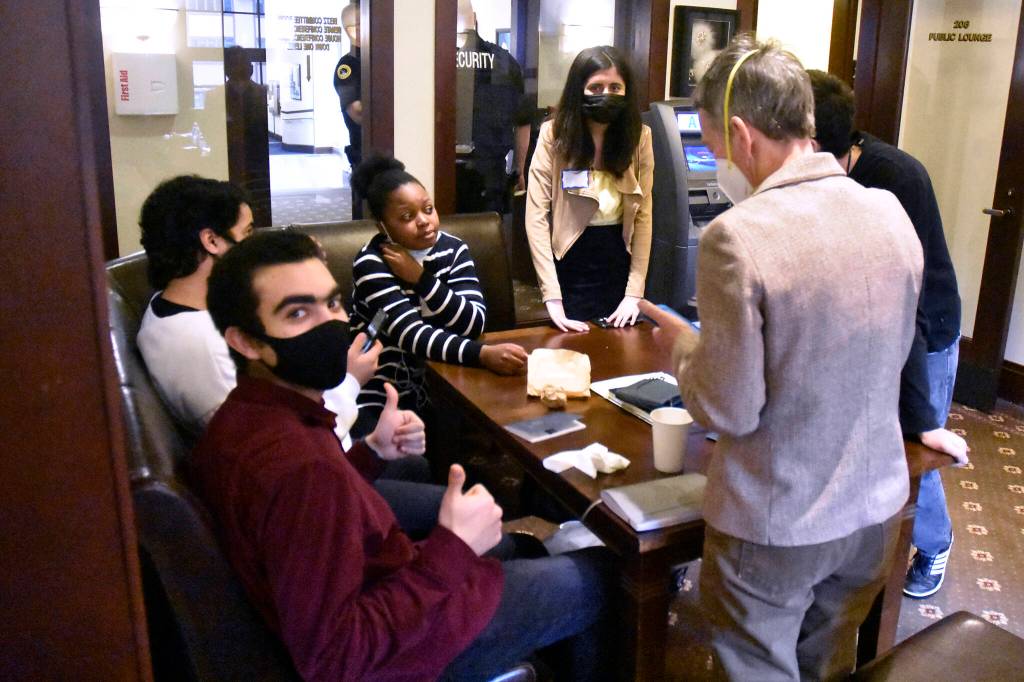 Peter Segall / Juneau Empire 
Ahmed Raza, an international exchange student from Bahrain, gives a thumbs up during a lunch break at the Alaska State Capitol on Wednesday, March 16, 2022. Also pictured are Mohammed Alnayhoum of Lybia, Sharon Shabon of Kenya, Abira Raza (no relation) of Pakistan, Arman Mkrtchyan of Armenia and exchange program volunteer Krisanne Rice.