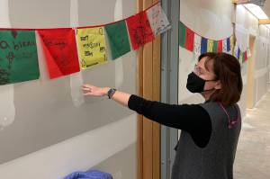 Michael S. Lockett / Juneau Empire 
Riverbend Elementary School principal Elizabeth Pisel-Davis gestures at drawings of things schoolchildren were thankful for that currently decorate the walls of the school after massive flooding from a burst pipe in January meant much the schools interior had to be gutted.