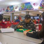 A.J. Wilson, 17, DeAndre Pittman, 16, and Elora Johnson, 16, eat lunch Thursday in the Juneau-Douglas High School: Yadaa.at Kalé cafeteria. They, like many students, agree the free meals available during the pandemic are worth continuing if funding can be found after it ends June 30, but they are likely to look off-campus for food if they are required to pay for school lunches again. (Mark Sabbatini / Juneau Empire)