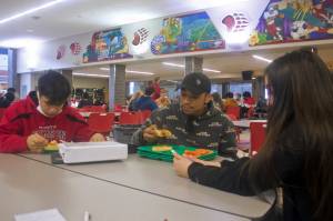 A.J. Wilson, 17, DeAndre Pittman, 16, and Elora Johnson, 16, eat lunch Thursday in the Juneau-Douglas High School: Yadaa.at Kalé cafeteria. They, like many students, agree the free meals available during the pandemic are worth continuing if funding can be found after it ends June 30, but they are likely to look off-campus for food if they are required to pay for school lunches again. (Mark Sabbatini / Juneau Empire)