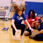 Paige Hansen, 12, of Petersburg competes in the kneel jump Saturday during the 2022 Traditional Games at Thunder Mountain High School while officials Ezra Elisoff and Anna Eason observe. Hansen said the kneel jump is her favorite event. (Ben Hohenstatt / Juneau Empire)