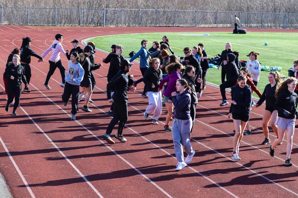 The JDHS track and field team does a warm-up exercise during practice at TMHS on April 14, 2022. (Michael S. Lockett / Juneau Empire)