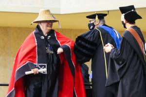 Robert Yates, left, receives his certificate for Indigenous language teaching during the commencement ceremony for University of Alaska Southeast on May 1, 2022. (Michael S. Lockett / Juneau Empire)