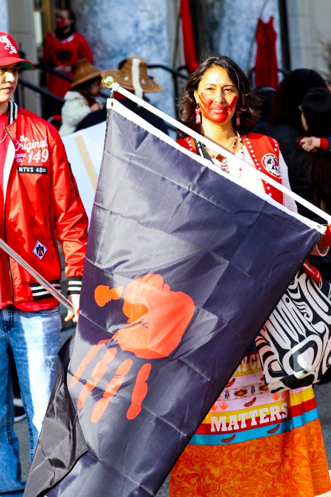 Jamiann Hasselquist holds a flag bearing the red hand, long associated with Murdered and Missing Indigenous Women, during the annual Missing and Murdered Indigenous Persons rally at the Alaska State Capitol on May 5, 2022. (Michael S. Lockett / Juneau Empire)