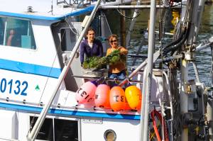 Capt. Bonny Millard of the FV San Juan tosses the commemorative wreath during the annual Blessing of the Fleet at the Alaska Commercial Fishermens Memorial in Juneau on May 7, 2022. (Michael S. Lockett / Juneau Empire)