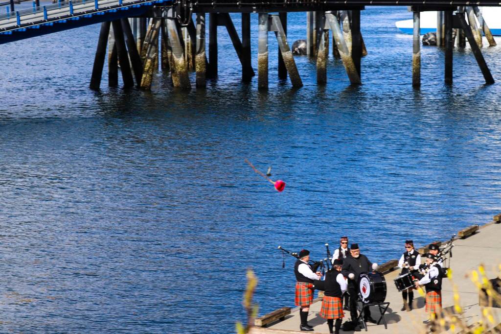 Attendees throw flowers during the annual Blessing of the Fleet at the Alaska Commercial Fishermens Memorial in Juneau on May 7, 2022. (Michael S. Lockett / Juneau Empire)