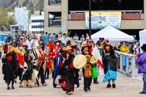 Photos by Michael S. Lockett / Juneau Empire
Members of the Yées Ku.oo multicultural dance group advance up the pier Saturday during the 12th Annual Maritime Festival. Below left, sailors strive against Juneau Docks and Harbors personnel in a tug-of-war. Below right, a swimmer drops out of a Coast Guard Air Station Sitka MH-60 Jayhawk during a rescue demonstration.