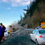 People run from a landslide just outside the downtown area of Seward, Alaska, May 7, 2022. There were no reported injuries in the landslide, which the city estimates could take up to two weeks to clear. (Josh Gray via AP)