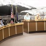 Juneau City Finance Director Jeff Rogers, left, explains how $5,500 payments to residents approved by the Alaska Senate may endanger a $16 million school bond reimbursement payment to the city during a meeting of the Juneau Assembly’s Finance Committee on Wednesday. (Mark Sabbatini / Juneau Empire)