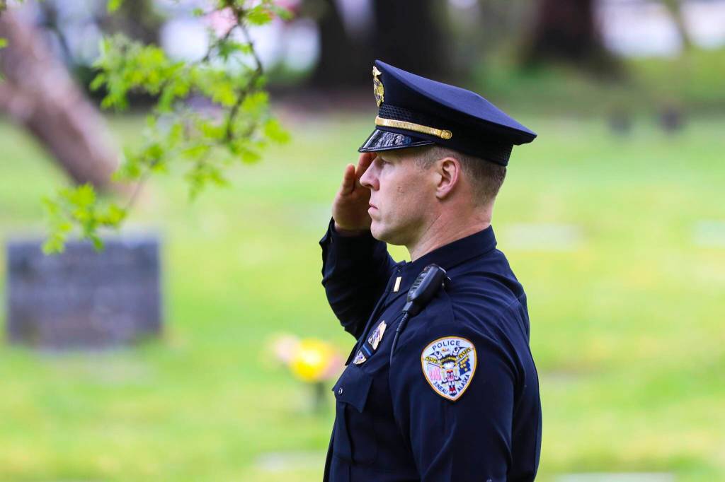 Michael S. Lockett / Juneau Empire
Lt. Krag Campbell of the Juneau Police Department salutes as officers lay a wreath on the grave of an officer who was killed on duty during a Peace Officers Memorial Day ceremony at Evergreen Cemetery on May 13, 2022.