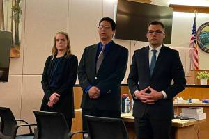 Michael S. Lockett / Juneau Empire
Left to right, investigator Emily Chapel, defendant Fenton Jacobs and defense attorney Nicolas Ambrose stand as the jury in Jacobs trial enters the courtroom on May 18, 2022.