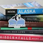 A magnet promoting the Alaska Reads Act released sits atop a stack of Alaskan-authored and Alaska-centric books. Lawmakers passed the Alaska Reads Act on the last day of the legislative session, but several members of the House of Representatives were upset with the bill, and the way it was passed. (Ben Hohenstatt / Juneau Empire)