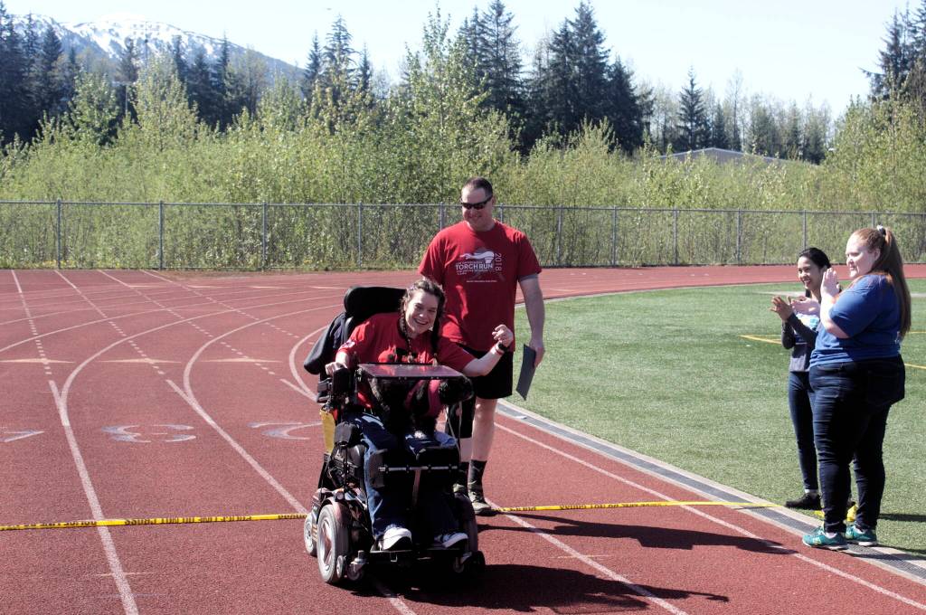 Sabrina Richmond, the lone wheelchair racer in the local Alaska Law Enforcement Torch Run on Saturday, crosses the finish line with her dog Koa. (Mark Sabbatini / Juneau Empire)