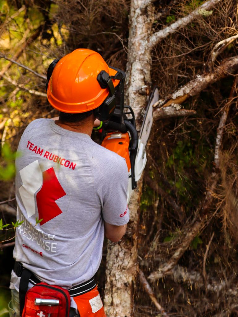 Brian Rougeux, a volunteer with Team Rubicon, practices his chainsaw technique on a downed tree as part of a training event for the disaster-relief organization on Douglas Island on May 25, 2022. (Michael S. Lockett / Juneau Empire)