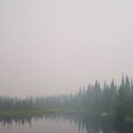 Fire smoke obscures the view of a canoeist and the sun in July 2004. (Courtesy Photo / Ned Rozell)