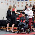 Mark Sabbatini / Juneau Empire 
Hannah Lynn Kadinger is wheeled across the stage after being the first senior to receive a diploma during the Juneau-Douglas High School: Yadaa.at Kalé graduation ceremony Sunday.