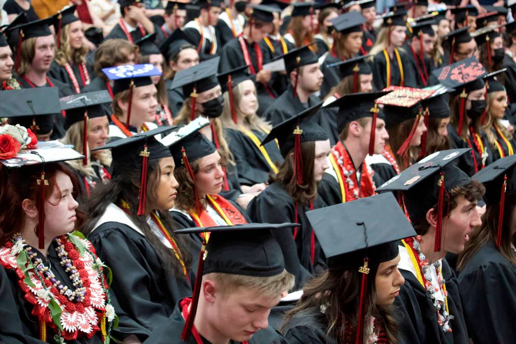 Mark Sabbatini / Juneau Empire 
Seniors at Juneau-Douglas High School: Yadaa.at Kalé listen to the keynote speech by Kate Troll, a longtime author/artist/activist, during Sundays graduation ceremony.