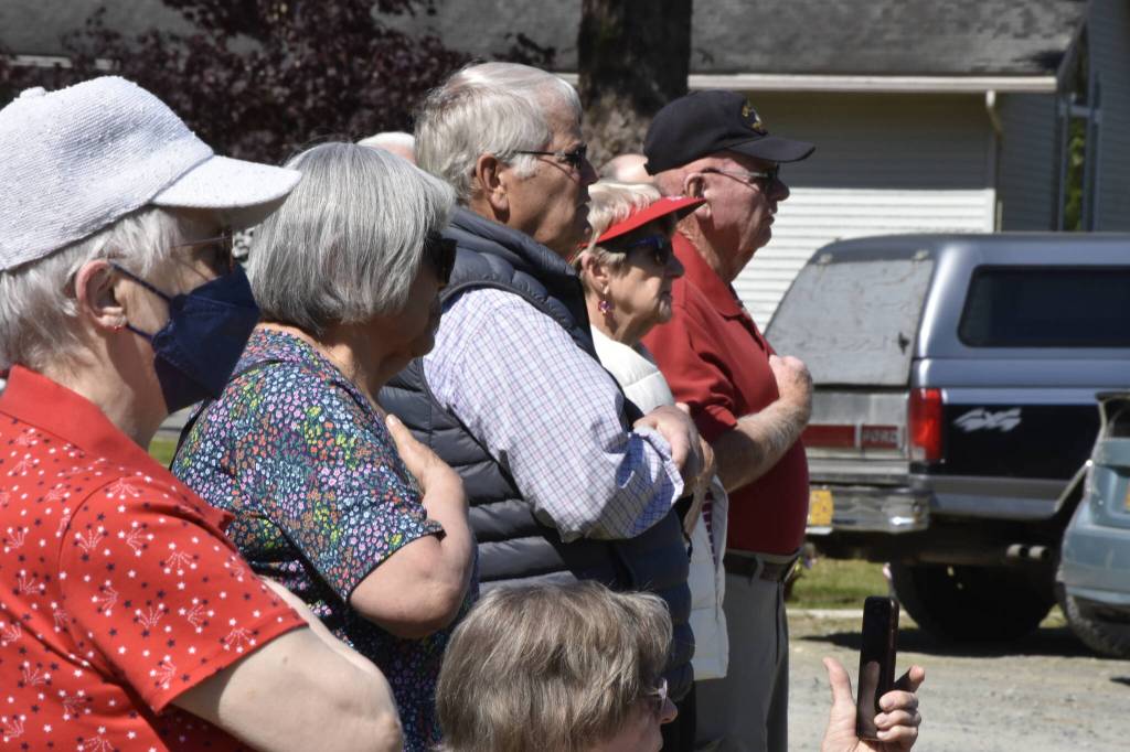 Attendees at a Memorial Day ceremony at Alaska Memorial Park hold their hands over their hearts while the national anthem is sung by a Thunder Mountain High School student on Monday, May 30, 2022. (Peter Segall / Juneau Empire)