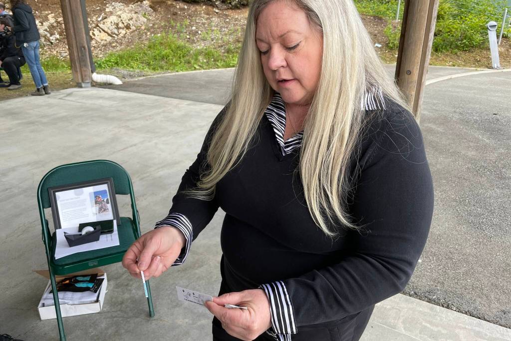 Denise Ewing, mother of Gabe Johnston, whose death galvanized the creation of Project Gabe, demonstrates a fentanyl test strip on June 10, 2022. Volunteers assembled 150 opioid overdose kits for the project. (Michael S. Lockett / Juneau Empire)