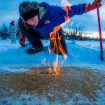 Courtesy Photo / Todd Paris, UAF 
Katey Walter Anthony inspects flaming methane gas seeping from a hole in the ice on the surface of a pond on the UAF campus in February 2016.
