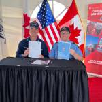 Rear Adm. Nathan Moore, U.S. Coast Guard 17th District, commander, left, and Neil ORourke, Canadian Coast Guard Arctic Region, assistant commissioner, holding the officially signed Beaufort Sea Annex, at Hay River Base, Northwest Territories, Canada, June 8, 2022. (PO2 Alexandria Preston / USCG)