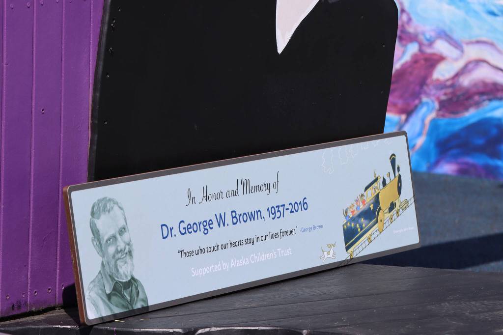 A plaque honoring Dr. George Brown was installed Saturday in Juneaus Project Playground. The train on the plaque was created by John Brown, George Browns brother. John Brown traveled from Texas to attend the event. (Ben Hohenstatt / Juneau Empire)