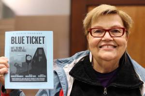 Playwright Maureen Longworth holds up a playbill for "Blue Ticket." The play, which tells a story inspired by stories from Juneau's past shared with Longworth is making it's on-screen debut during Pride Month. The play debuted on stage in 2019. (Clarise Larson / Juneau Empire)