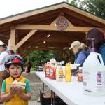 Kobe Rielly grabs a hot dog Wednesday evening at the grand unveiling of the new pavilion at Riverside Rotary Park. (Clarise Larson / Juneau Empire)