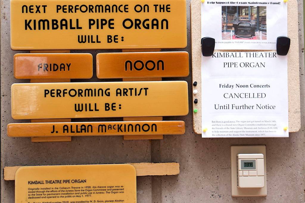A sign next to a wooden plaque announces regular performances on the Kimball Theatre Pipe Organ are on hold indefinitely. Fundraising efforts to maintain the instrument have been made for years, but it now needs extra care due to inactivity during the COVID-19 pandemic. (Mark Sabbatini / Juneau Empire)