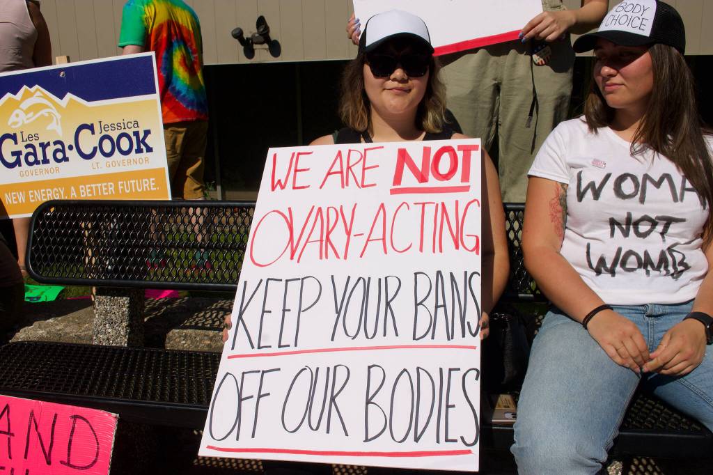 Ayanna Lind, 21, holds her hand-made sign that she brought to the protest. Lind said she felt it necessary to come to the protest after the reversal was made. (Clarise Larson / Juneau Empire)