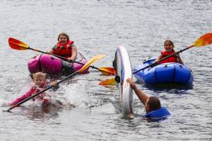 Petty Officer 2nd Class William Peters tips Matthew Shockley into Twin Lakes on June 30, 2022 as part of a boating safety class. (Michael S. Lockett / Juneau Empire)