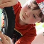 Kingston Wilson, 7, applies reflective decorations to a bike on July 3, 2021. Dozens of youths showed up to decorate their bikes. (Ben Hohenstatt / Juneau Empire)