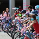 Douglas kids line up with their freshly decorated rides during the Douglas Fourth of July Committees annual Bicycle Decorating session held at the Douglas Public Library on July 2, 2022. (Michael S. Lockett / Juneau Empire)