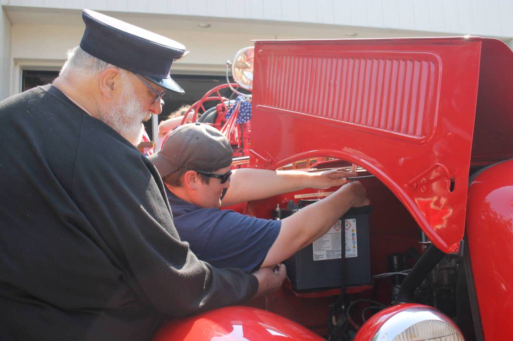 Volunteers at the Douglas Fire Hall make some quick repairs to the fire engine ahead of the Douglas Parade. (Clarise Larson / Juneau Empire)