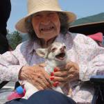 Jessie Skrzyhski (95) holds her screaming/barking dog, Charlie, while enjoying the parade. (Clarise Larson / Juneau Empire)