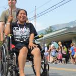 A parade participant holds a patriotic flag as she makes her way down the street. (Clarise Larson / Juneau Empire)