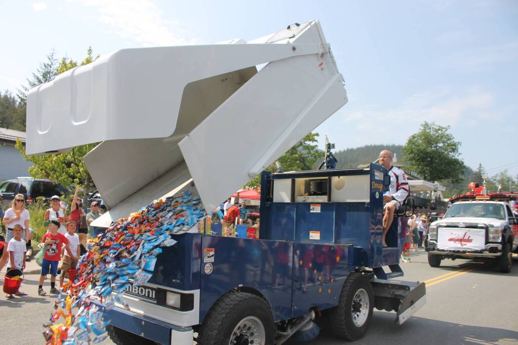 The Juneau Douglas Ice Associations Zamboni dumps candy onto the street and ensues a swarm of kids  and adults  who quickly run to grab a handful or two. (Clarise Larson / Juneau Empire)