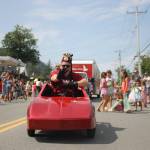 A Juneau-Douglas Shrine Club member rides in a serpentine pattern as kids chase him for candy. (Clarise Larson / Juneau Empire)