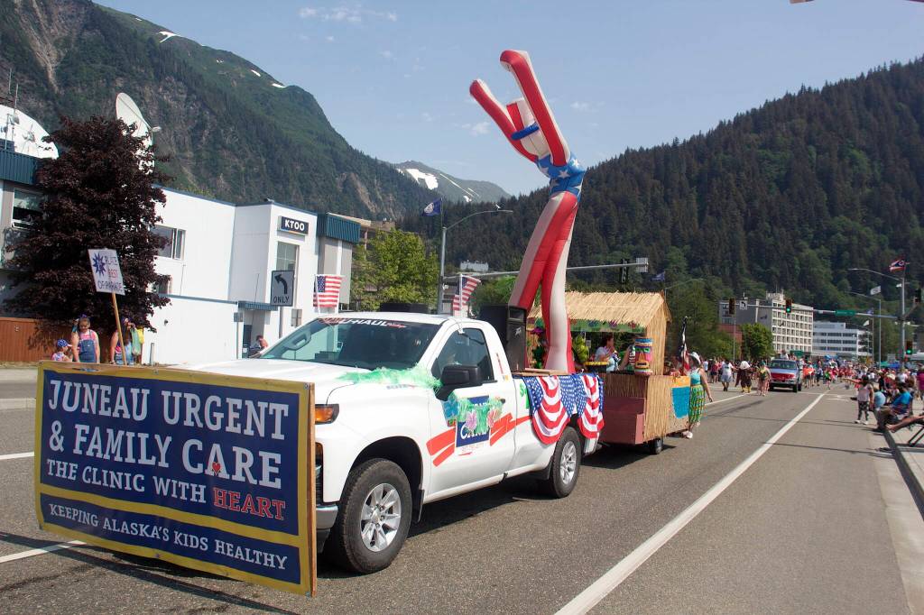 A towering inflatable Uncle Sam waves to the crowd from the Hawaiian-themed Juneau Urgent Care float that was won the Best of Parade award in this years downtown July 4 parade. (Mark Sabbatini / Juneau Empire)