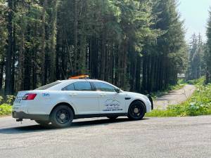 A Juneau Police Department community service officer vehicle cordons off a road as officers took a man wanted on a $50,000 warrant into custody. (Jonson Kuhn / Juneau Empire)