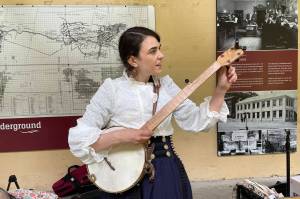 Annie Bartholomew prepares her banjo for rehearsal for her Victorian folk opera, Sisters of White Chapel, at the Treadwell Mine Office on July 5, 2022. (Michael S. Lockett / Juneau Empire)