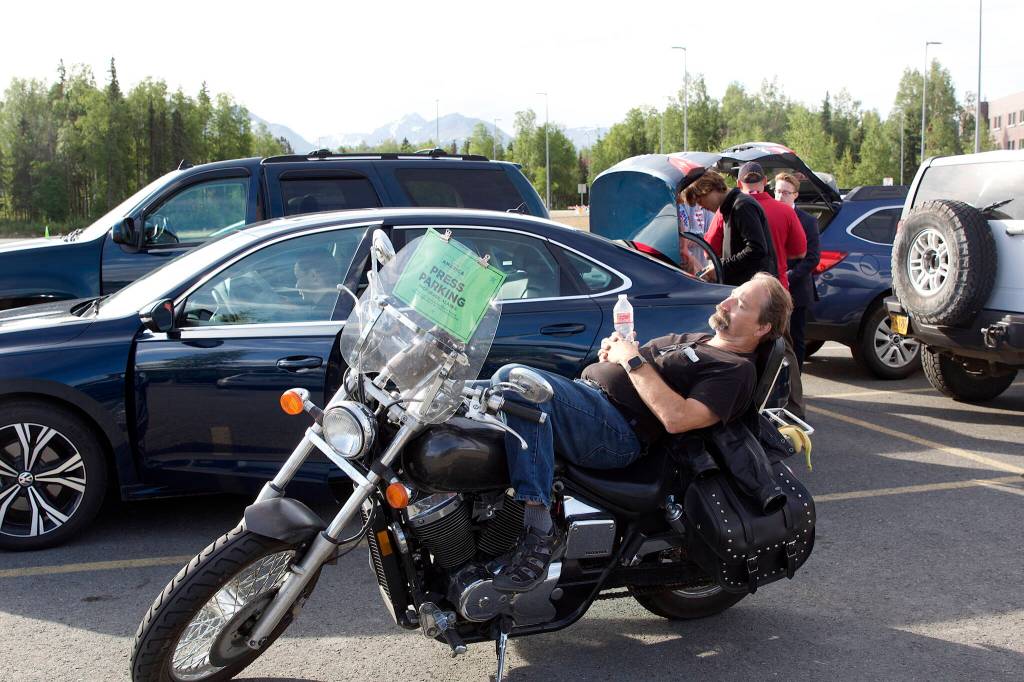 Kevin Kurka, a freelance Alaska journalist, takes a midmorning break on his motorcycle in the media parking lot at the Alaska Airlines Center on Saturday. (Mark Sabbatini / Juneau Empire)