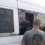 Phyllis Priest, co-owner of Bema Coffee Roasters, takes an order from a customer following the Save America rally Saturday. The food truck was one of only two at the event and the only one selling coffee drinks, ensuring a long line during most of the day. (Mark Sabbatini / Juneau Empire)
