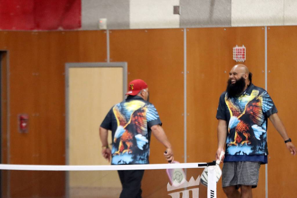 Sonatane Pasina and Freddie Vaenuku Jr. touch rackets Saturday during a pickleball tournament at Floyd Dryden High School. The Alaska Crimson Bear Pickleball Club hosted the San Francisco Eagles, whose club members donned noticeable shirts. (Ben Hohenstatt / Juneau Empire)