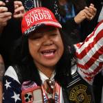 Mimi Israelah, center, cheers for Donald Trump inside the Alaska Airlines Center in Anchorage, Alaska, during a rally Saturday July 9, 2022. An investigation has been launched after a person believed to be an Anchorage, Alaska, police officer was shown in a photo with Israelah flashing a novelty “White Privilege card.” The social media post caused concerns about racial equality in Alaska’s largest city.  (Bill Roth / Anchorage Daily News)
