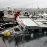 The owner of the Alaskan Shel and other bystanders work to outboard the water as the ship sinks. (Clarise Larson / Juneau Empire)