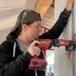Elizabeth Saunders, a member of Team Rubicon, installs drywall at a project site in Haines on July 22, 2022. (Michael S. Lockett / Juneau Empire)