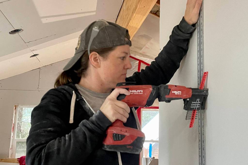 Elizabeth Saunders, a member of Team Rubicon, installs drywall at a project site in Haines on July 22, 2022. (Michael S. Lockett / Juneau Empire)