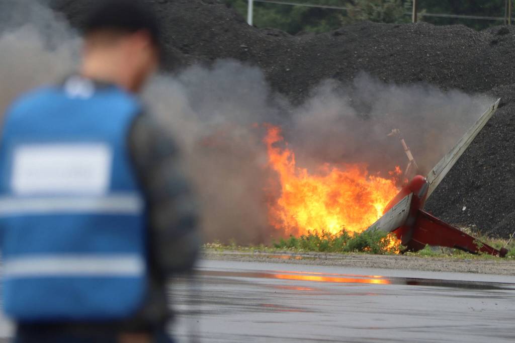 Deputy airport manager Phil Adams looks on as a small aircraft burns during a drill at Juneau International Airport. The drill held Saturday involved dozens of volunteers and several agencies. (Ben Hohenstatt / Juneau Empire)