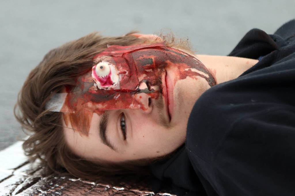 Kelton Griffith roleplays as a griveiously injured casualty during an exercise simulating a plane crash at Juneau International Airport on July 23, 2022. (Ben Hohenstatt / Juneau Empire)